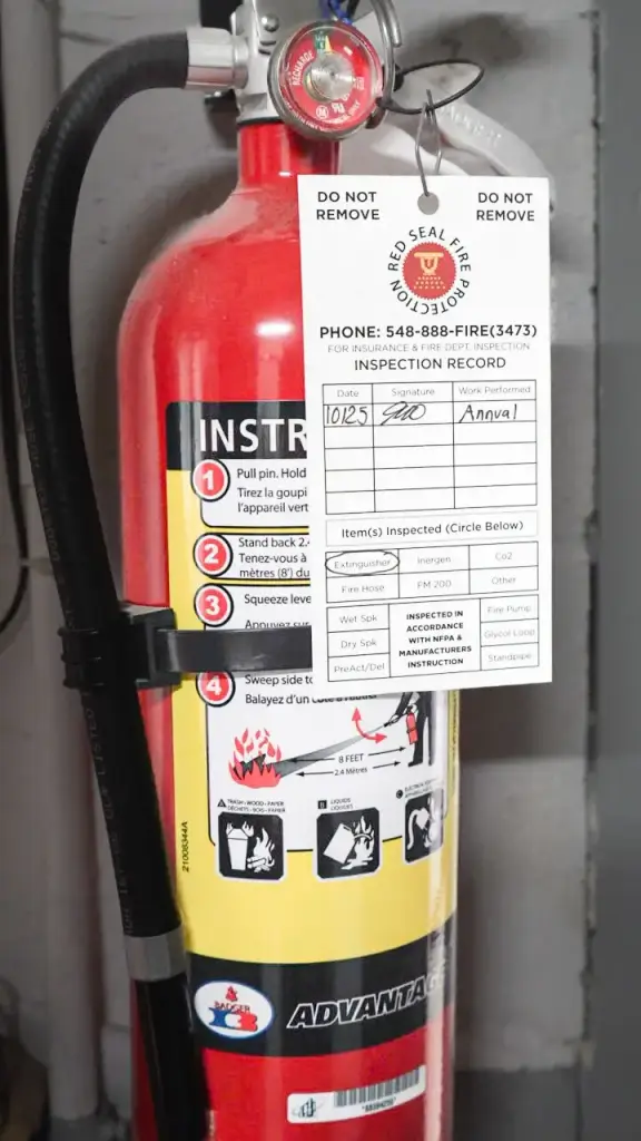 Fire extinguisher with a Red Seal inspection tag.
