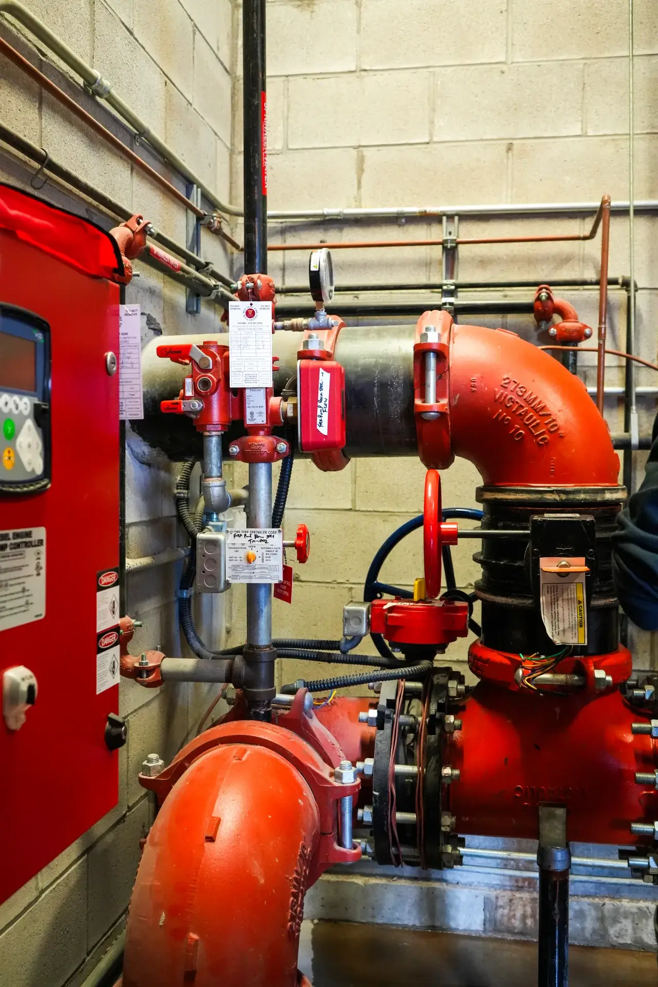 Sprinkler riser with valves and red piping.