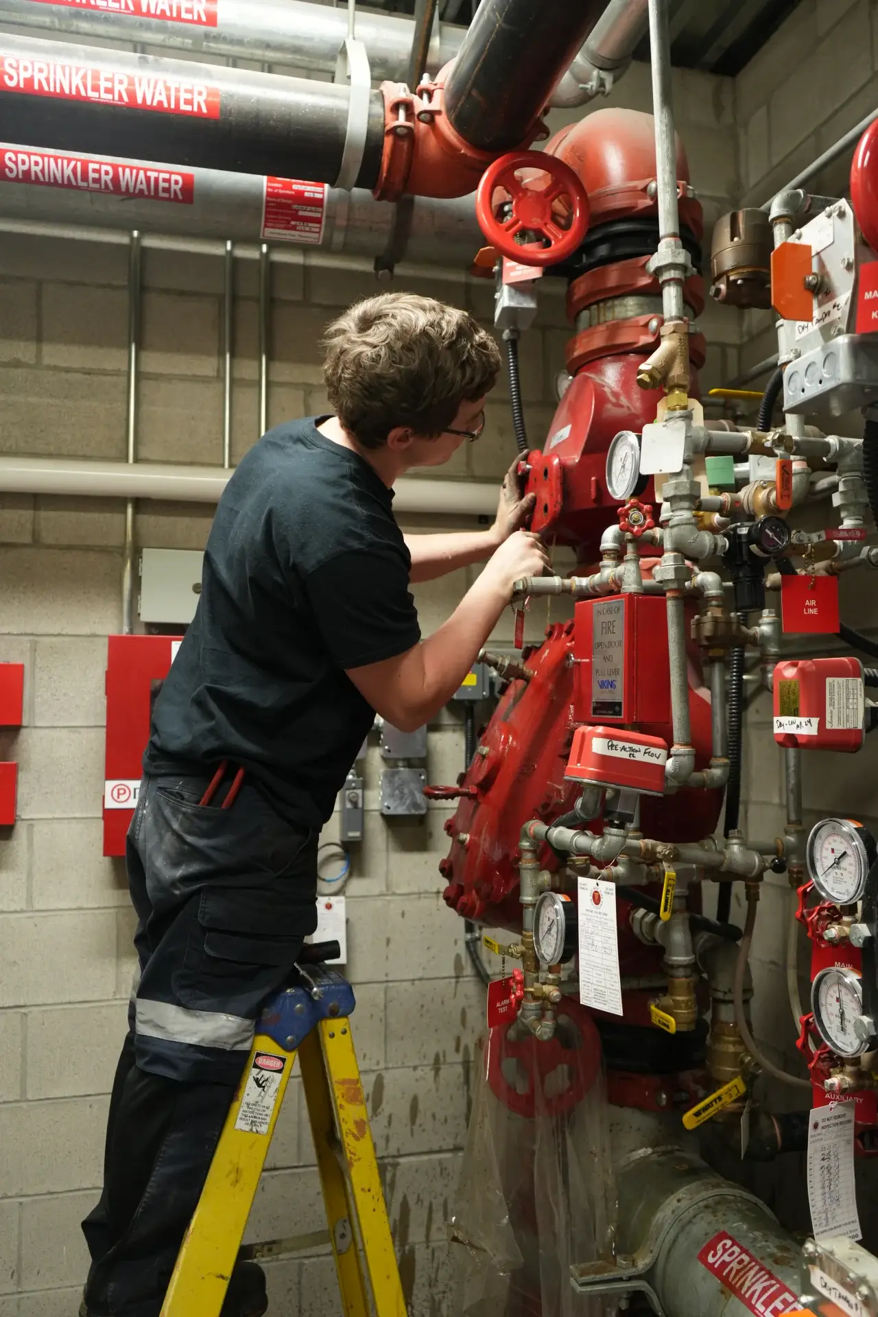 Red Seal technician working on sprinkler riser valves.