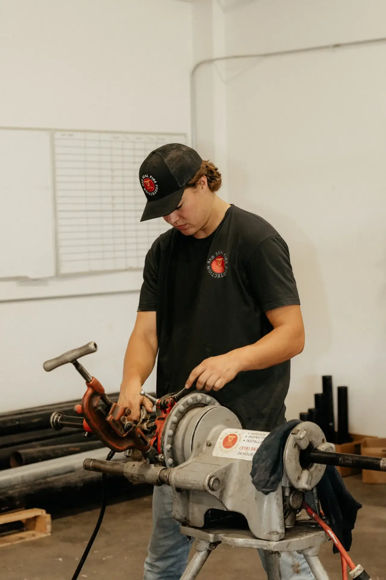 Red Seal technician preparing sprinkler pipe on a pipe machine.