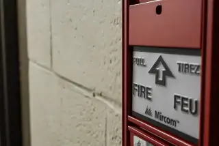 Fire alarm pull station mounted on a wall.